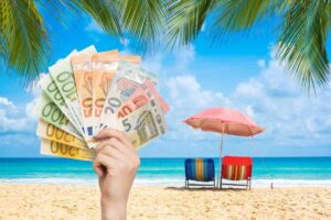 spiaggia caraibica e mano con soldi