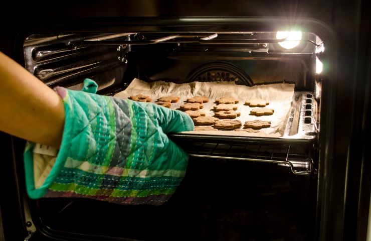 donna prende biscotti nel forno con carta